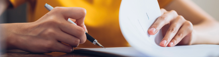 Une personne signe des documents